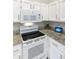 Clean kitchen featuring white appliances, granite countertops, ample cabinet space, and tile backsplash at 11115 E Bellflower Ct, Sun Lakes, AZ 85248