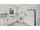 Bright kitchen featuring white cabinets, appliances, tile backsplash, and modern countertops at 1117 W Mesquite St, Chandler, AZ 85224