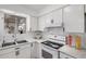 Bright kitchen featuring white cabinets, appliances, tile backsplash, and modern countertops at 1117 W Mesquite St, Chandler, AZ 85224