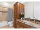 Bathroom with wooden cabinetry, granite countertops, and a shower/tub combo for all your needs at 11222 N 73Rd St, Scottsdale, AZ 85260