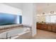 Bright and airy bathroom boasts a luxurious soaking tub and natural stone tile throughout at 11222 N 73Rd St, Scottsdale, AZ 85260