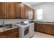 Well-equipped laundry room with modern washer/dryer, granite countertops, and ample cabinet space at 11222 N 73Rd St, Scottsdale, AZ 85260