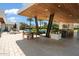 A covered patio area with a kitchen, seating, TV, and views of the pool at 11222 N 73Rd St, Scottsdale, AZ 85260