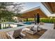 Backyard pool area featuring a covered outdoor kitchen, fireplace, and ample lounge seating at 11222 N 73Rd St, Scottsdale, AZ 85260