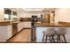 Well-lit kitchen with stainless steel appliances, granite countertops, a breakfast bar, and white cabinetry at 15035 N 54Th St, Scottsdale, AZ 85254