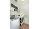 Bright laundry room featuring modern washer and dryer, storage shelves, and decorative laundry sign at 15035 N 54Th St, Scottsdale, AZ 85254