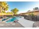 Sparkling pool with rock features surrounded by desert landscaping and a secure safety fence at 15035 N 54Th St, Scottsdale, AZ 85254