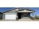 Charming single-story home featuring a gray stucco exterior, stone accents, and a two-car garage at 15744 W Beryl Ave, Waddell, AZ 85355