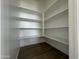 Walk in pantry with wood look flooring and plenty of shelving at 15744 W Beryl Ave, Waddell, AZ 85355