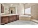 Bathroom featuring double vanity with soaking tub and a glass block window at 1738 W Yosemite Pl, Chandler, AZ 85248