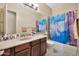 Functional bathroom with a vanity, mirror, toilet, and a shower/tub combination enclosed with a decorative curtain at 1738 W Yosemite Pl, Chandler, AZ 85248