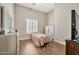 Cozy bedroom with laminate floors, a comfortable bed, dresser, and bright shuttered windows at 1738 W Yosemite Pl, Chandler, AZ 85248