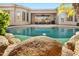 Beautiful pool with rock features, lush landscaping, and inviting outdoor seating at 1738 W Yosemite Pl, Chandler, AZ 85248