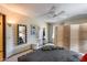 Bedroom with paneled folding screen, ceiling fan, mirror, and upholstered bed at 17428 N Boswell Blvd, Sun City, AZ 85373