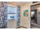 Bright living room featuring a large window with patterned curtains, tile flooring, and view into the main bedroom at 17428 N Boswell Blvd, Sun City, AZ 85373