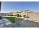 Backyard featuring artificial turf, a gravel bed, stepping stones, and a tall block fence at 17580 W Country Club Ter, Surprise, AZ 85387