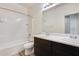 Bright bathroom featuring a double sink vanity and a shower over tub at 17580 W Country Club Ter, Surprise, AZ 85387