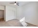 Bright bedroom featuring neutral carpet, a ceiling fan, and a closet with sliding doors at 17580 W Country Club Ter, Surprise, AZ 85387