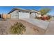 Exterior view of a single story home with a two-car garage and low maintenance desert landscaping at 17580 W Country Club Ter, Surprise, AZ 85387