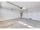 Empty two car garage with concrete floor, water heater and door at 17580 W Country Club Ter, Surprise, AZ 85387