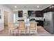 Stylish kitchen island with granite countertops, stainless steel appliances, and modern dark cabinetry at 17580 W Country Club Ter, Surprise, AZ 85387