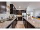 Kitchen with a large island, granite countertops, stainless steel appliances, and dark wood cabinetry at 17580 W Country Club Ter, Surprise, AZ 85387