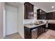 Kitchen with stainless steel appliances, granite countertops, and dark cabinets at 17580 W Country Club Ter, Surprise, AZ 85387