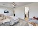 Bright main bedroom featuring neutral décor, ceiling fan, and ensuite bathroom access at 17580 W Country Club Ter, Surprise, AZ 85387