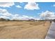 Expansive dry community field for activities, walking and recreation with neighborhood homes in background at 17580 W Country Club Ter, Surprise, AZ 85387