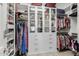 Organized walk-in closet featuring custom shelving, drawers, glass-front cabinets and plenty of storage at 18068 E Curva De Plata --, Rio Verde, AZ 85263