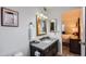 Bright bathroom showcasing a dark wood vanity with gray countertop and a large, bright gold mirror at 18624 N 92Nd Dr, Peoria, AZ 85382