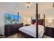 Bedroom with a large window, chandelier, and a four-poster bed with elegant dark wood furniture at 18624 N 92Nd Dr, Peoria, AZ 85382