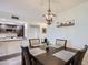 Dining area with an elegant light fixture and a view into the adjacent kitchen at 18624 N 92Nd Dr, Peoria, AZ 85382