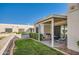 Back patio with barbecue and seating overlooks a beautifully manicured lawn at 18624 N 92Nd Dr, Peoria, AZ 85382