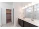 Primary bathroom with double sink vanity, large mirror, and a walk-in shower behind glass door at 18743 N Avelino Dr, Maricopa, AZ 85138