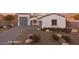 Beautiful home with a charming desert landscape, elegant facade, and a spacious driveway leading to a two-car garage at 18743 N Avelino Dr, Maricopa, AZ 85138