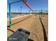 Community playground featuring an orange slide, teal supports, and soft ground cover at 18743 N Avelino Dr, Maricopa, AZ 85138