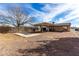 Large backyard featuring a gravel area, covered patio, and partial fencing, offering outdoor possibilities at 200 E Rose Ln, Avondale, AZ 85323