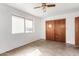 Bedroom featuring white walls, a window, closet, and ceiling fan at 200 E Rose Ln, Avondale, AZ 85323