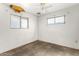 Bedroom with two windows, white walls, and a ceiling fan at 200 E Rose Ln, Avondale, AZ 85323