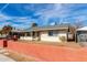 A charming single-story home with a painted concrete perimeter, set against a bright sky at 200 E Rose Ln, Avondale, AZ 85323