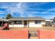 Charming single-story home with a decorative block wall, featuring a gray roof and well-lit, classic facade at 200 E Rose Ln, Avondale, AZ 85323