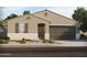 Charming single-story home with neutral stucco, desert landscaping, and attached two-car garage at 20310 N 225Th Dr, Surprise, AZ 85387