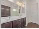 Bathroom with double vanity, dark wood cabinets, and two mirrors at 20931 E Via Del Sol St, Queen Creek, AZ 85142