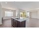 Spacious kitchen island with stainless faucet and dark wood cabinets, open to the dining area and backyard access at 20931 E Via Del Sol St, Queen Creek, AZ 85142