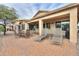 Covered back patio with brick pavers, lounge chairs, table, and seating at 2477 E Valencia Dr, Casa Grande, AZ 85194