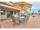 Outdoor dining set with umbrella in the back patio area at 2477 E Valencia Dr, Casa Grande, AZ 85194