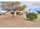 View of the desert landscaped backyard with a covered patio and outdoor seating area at 2477 E Valencia Dr, Casa Grande, AZ 85194