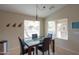 Cozy dining area with backyard views, a modern light fixture, and comfortable seating for four at 2477 E Valencia Dr, Casa Grande, AZ 85194