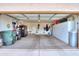 View of the open garage with white storage cabinets and a black refrigerator at 2477 E Valencia Dr, Casa Grande, AZ 85194